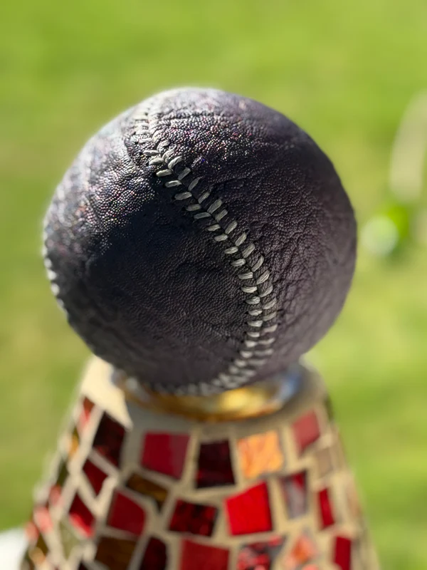 Dark textured exotic baseball on mosaic stand